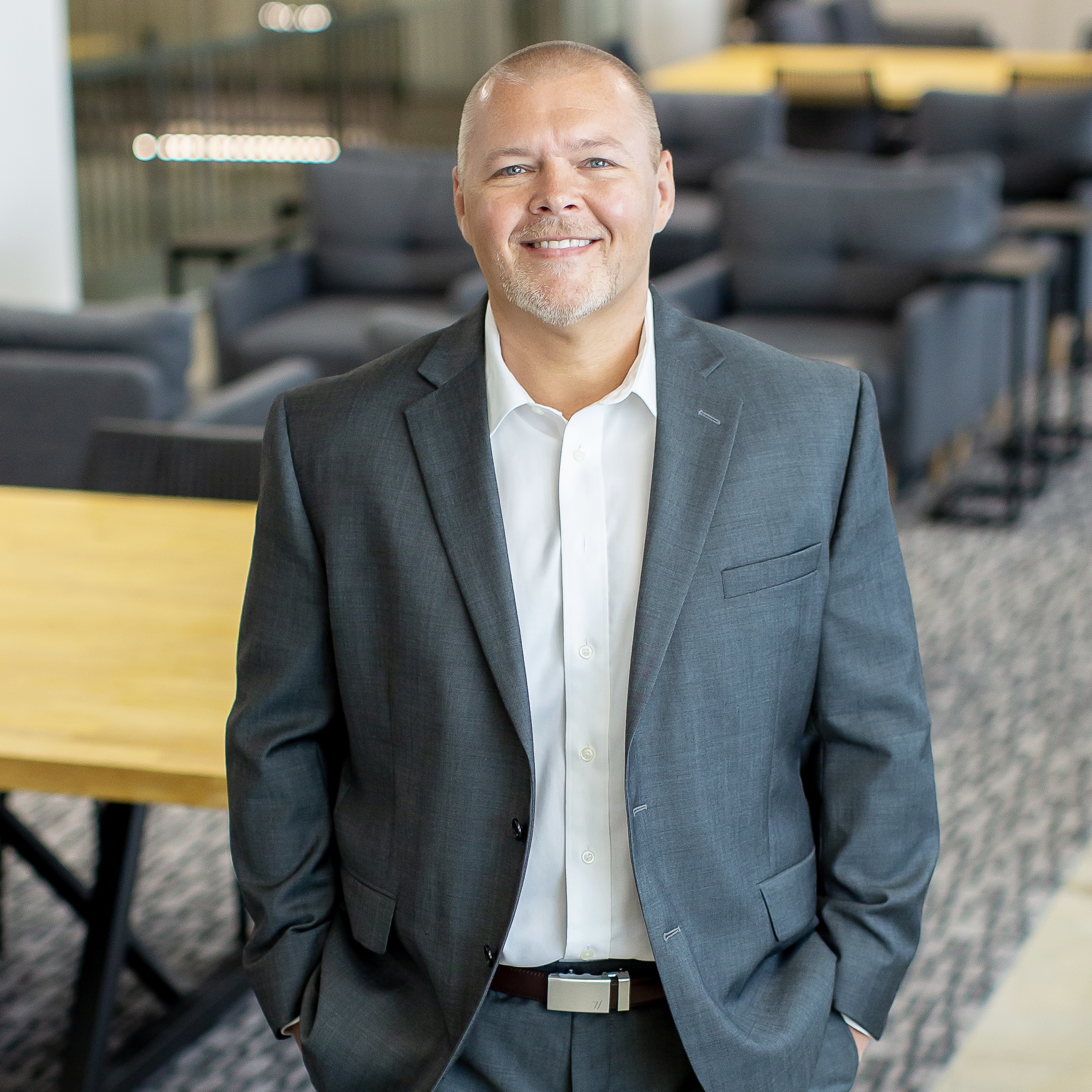 Brandon Adams standing in an open space office area.